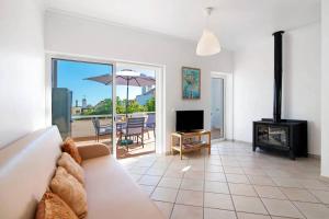 ein Wohnzimmer mit Couch und Kamin in der Unterkunft Apartamento T1 Santa Luzia 2D in Santa Luzia