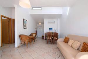 ein Wohnzimmer mit Sofa, Stühlen und einem Tisch in der Unterkunft Apartamento T1 Santa Luzia 2D in Santa Luzia + 15 Fotos