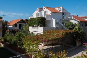 a white house with red roofs and ivy at Apartments Holiday Žaborić in Zaboric