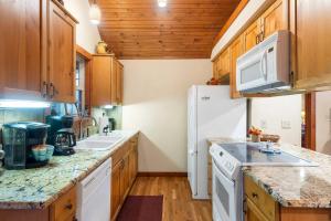a kitchen with white appliances and wooden cabinets at Creekside - 2 BDR Resort Cabin in Epic Location in Branson West