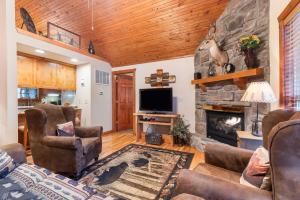 a living room with a fireplace and a tv at Creekside - 2 BDR Resort Cabin in Epic Location in Branson West +17 photos