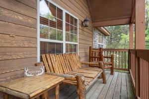 a wooden bench sitting on a porch of a cabin at Simon's Treetop Cabin - 2 BDR in Popular Resort in Branson West