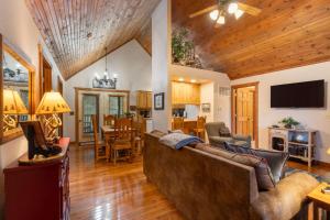 a living room with a couch and a dining room at Simon's Treetop Cabin - 2 BDR in Popular Resort in Branson West