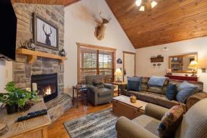 a living room with a fireplace and a stone wall at Simon's Treetop Cabin - 2 BDR in Popular Resort in Branson West