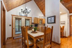a kitchen and dining room with a wooden table and chairs at Simon's Treetop Cabin - 2 BDR in Popular Resort in Branson West +16 photos