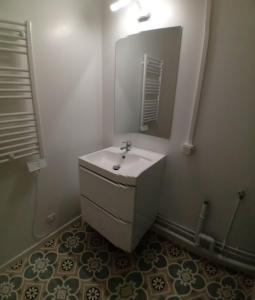 a bathroom with a white sink and a mirror at Le Germini in Mirecourt