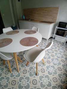 a kitchen with a table with four chairs and a counter at Le Germini in Mirecourt
