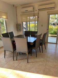 ein Esszimmer mit einem schwarzen Tisch und Stühlen in der Unterkunft Aranduroga in Corrientes