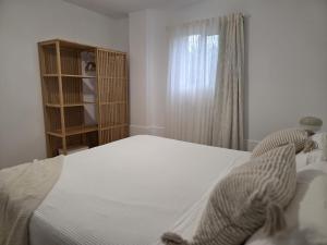 a bedroom with a white bed and a window at Gardel Esencia in Icod de los Vinos +8 photos