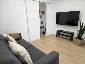 a living room with a couch and a flat screen tv at Gardel Esencia in Icod de los Vinos