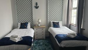 1 Schlafzimmer mit 2 Betten, einer Kommode und einem Fenster in der Unterkunft Seaside Escape in Thorpe Bay