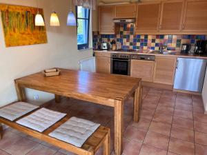 a kitchen with a wooden table and a wooden bench at Ferien unterm Reet in Prerow