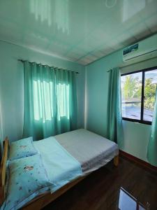 a small bedroom with a bed with a window at PA L Residence in Euscara
