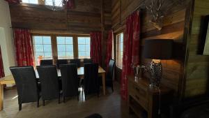 a dining room with a table and black chairs at Jean in Grimentz