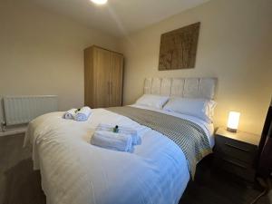 a bedroom with a white bed with towels on it at 3 Bedroom, Parking, 2 Toilets, Wi-Fi, Modern in Crewe