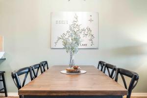 a dining room table with a vase of flowers on it at Sunset Daydream - Elegant Condo on Table Rock in Branson