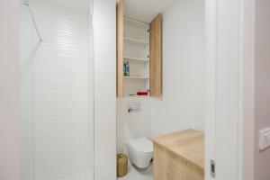 ein weißes Badezimmer mit Toilette und Dusche in der Unterkunft La Gloire by Blvd 8B2 - Premium Studio Retreat in Bukarest
