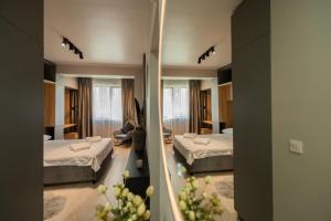 ein Hotelzimmer mit zwei Betten und einem Spiegel in der Unterkunft La Gloire by Blvd 8B2 - Premium Studio Retreat in Bukarest