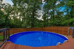 a large blue pool on a deck with a wooden fence at Teal's Treasure - Secluded Lakeside Cabin for 8 in Kirbyville