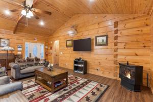 a living room with a fireplace and a flat screen tv at Teal's Treasure - Secluded Lakeside Cabin for 8 in Kirbyville