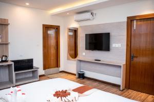 ein Schlafzimmer mit einem Bett und einem Fernseher an der Wand in der Unterkunft Hotel Badrinath in Kathmandu