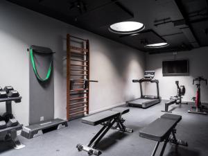 a gym with several tread machines and a television at Sand Hotel by Keahotels in Reykjavík