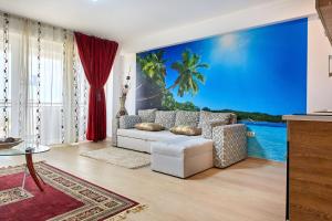Una sala de estar con un sofá blanco y un mural de una palmera. en Apartament B B Boutik C, en Eforie Sud