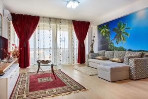 sala de estar con sofá blanco y cortinas rojas en Apartament B B Boutik C, en Eforie Sud