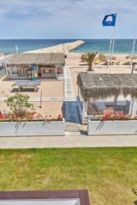 Una vista de una playa con una bandera y un edificio. en Apartament B B Boutik C, en Eforie Sud