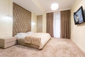 a hotel room with a bed and a flat screen tv at Central Elegant Apartment in Tbilisi City +19 photos