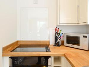 a kitchen with a counter top with a microwave at Boatman's Cottage At Invernian Mor in Inverinan Beg