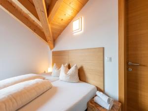 two beds in a room with white walls and wooden ceilings at Luxury penthouse with Balcony, Ski Storage, Carport, Lift in Brixen im Thale