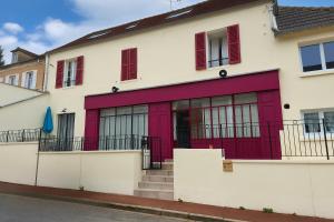 a white building with red doors and stairs at l'Ancien Bistrot in Saint-Martin-de-Bréthencourt