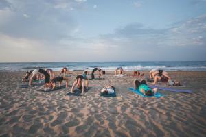 a group of people laying in the sand on the beach at Tres Estrellas Barcelona by HolaCamp in Gavà