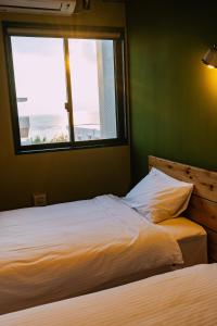 a bed in a room with a large window at The Shore Inn in Chatan