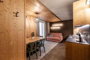 a kitchen and living room with a table and a couch at El Giof Alpine Home in Pellizzano