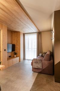 a living room with a couch and a television at El Giof Alpine Home in Pellizzano