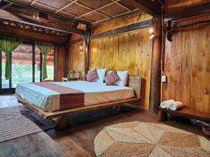 ein Schlafzimmer mit einem Bett in einem Zimmer mit Holzwänden in der Unterkunft Ruộng Cafe & Homestay in Cao Phong