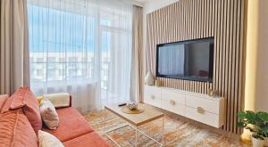 un salon avec un canapé et une télévision dans l'établissement HolidayHomePL Bel Mare F540 z balkonem, à Międzyzdroje