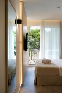 a bedroom with a bed and a large window at Cabot Cala Ferrera in Cala d´Or +70 photos