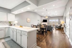 a kitchen and dining room with white cabinets and a table at Great Escape Duo in Branson