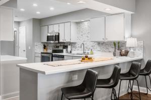 a kitchen with white cabinets and a counter with chairs at Great Escape Duo in Branson