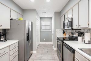 a kitchen with white cabinets and a stainless steel refrigerator at Great Escape Duo in Branson +49 photos