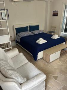 a bedroom with a large bed and a couch at B&B Villa Mediterranea with private parking in Trani