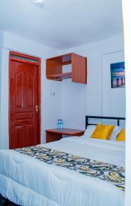a bedroom with two beds and a red door at Lake View Suites, Homa Bay in Homa Bay