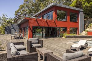 une maison sur une terrasse en bois avec des chaises et des tables dans l'établissement Carmim Villa by Cadenzalux, à Biscaia