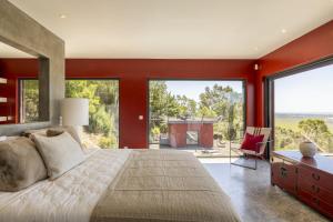 une chambre aux murs rouges et un grand lit avec un bureau dans l'établissement Carmim Villa by Cadenzalux, à Biscaia 64 autres photos