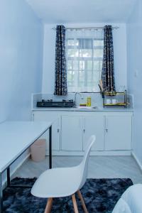 a white desk with a white chair in a room at Lake View Suites, Homa Bay in Homa Bay