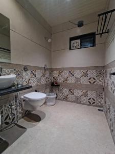 un baño con inodoro y lavabo en Peach stay, en Mount Abu