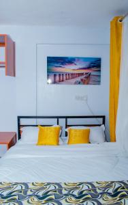 a bedroom with a bed with two yellow pillows at Lake View Suites, Homa Bay in Homa Bay